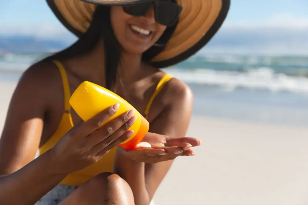 Woman applying sunscreen on the beach